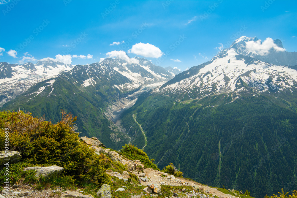 Picturesque panoramic view of the snowy Alps mountains, the Mont Blanc mountain and glacier and meadows while hiking Tour du Mont Blanc. Popular hiking route. Alps, Chamonix-Mont-Blanc region, France 