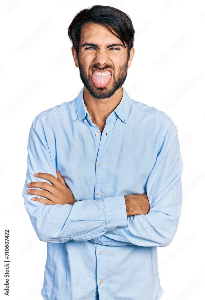 Hispanic man with blue eyes with arms crossed gesture sticking tongue out happy with funny expression. Hispanic man with blue eyes with arms crossed gesture sticking tongue out happy with funny expression.