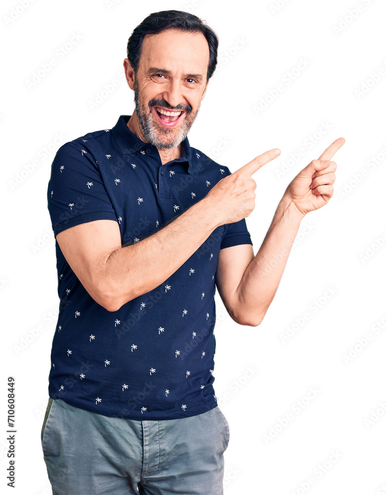 Middle age handsome man wearing casual polo smiling and looking at the camera pointing with two hands and fingers to the side. Middle age handsome man wearing casual polo smiling and looking at the camera pointing with two hands and fingers to the side.