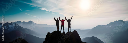 Together overcoming obstacles with three people holding hands up in the air on mountain top , celebrating success and achievements photo