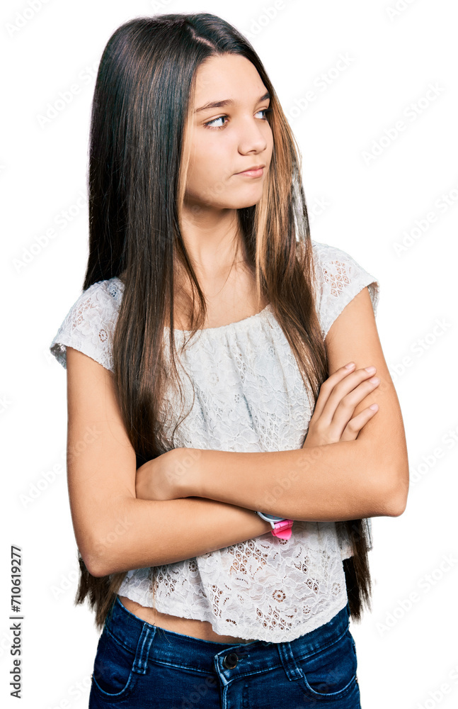 Young brunette girl with long hair wearing white shirt looking to the side with arms crossed convinced and confident Young brunette girl with long hair wearing white shirt looking to the side with arms crossed convinced and confident