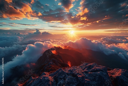 Breathtaking mountain sunset with clouds rolling over rugged peaks, warm sunlight casting a golden glow.