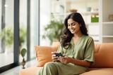 A portrait of an indian lady using a smart home app on his phone sitting on a couch, 