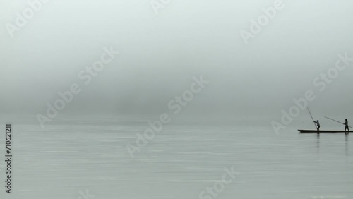 Early calm morning with fog on the Rio Napo, Ecuador, South America Local children take a boat ride on theRio Napo. ProRes footage. photo