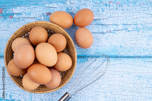 Brown eggs in a wooden weave basket on wooden floor. photo