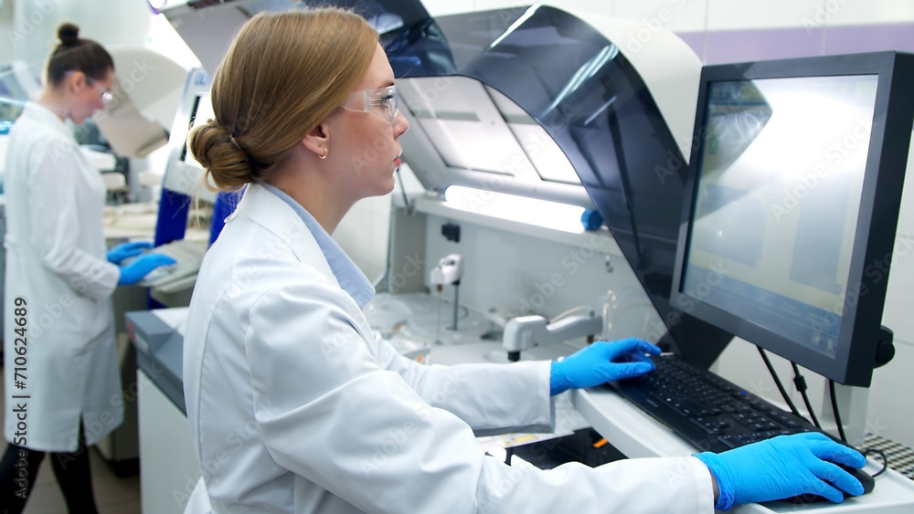 A medical research laboratory with a diverse team of biochemical scientists working with computers and modern medical technologies. Development of high-tech equipment for medicines. A medical research laboratory with a diverse team of biochemical scientists working with computers and modern medical technologies. Development of high-tech equipment for medicines.