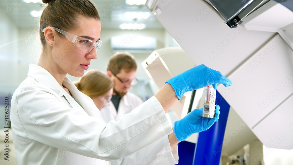 A medical research laboratory with a diverse team of biochemical scientists working with computers and modern medical technologies. Development of high-tech equipment for medicines. A medical research laboratory with a diverse team of biochemical scientists working with computers and modern medical technologies. Development of high-tech equipment for medicines.