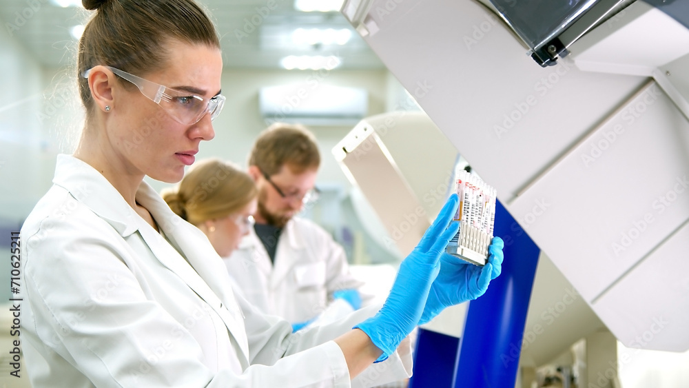 A medical research laboratory with a diverse team of biochemical scientists working with computers and modern medical technologies. Development of high-tech equipment for medicines. A medical research laboratory with a diverse team of biochemical scientists working with computers and modern medical technologies. Development of high-tech equipment for medicines.