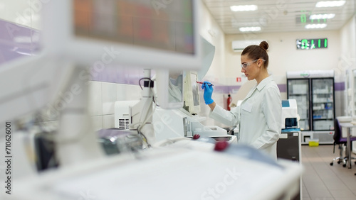 A female scientist controls the operation of devices for laboratory research. Modern laboratory technologies. Medical research centrifuge. photo