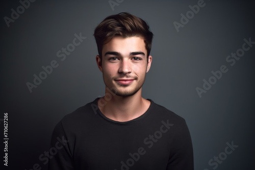 studio shot of a handsome young man against a grey background