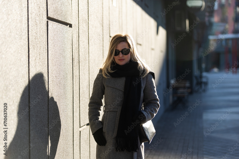 Obraz premium A young girl blonde walks through the city