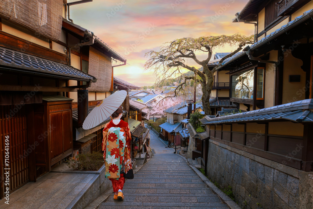 Fototapeta premium Scenic sunset of Nineizaka or Ninenzaka, ancient pedestrian road in Kyoto, Japan with a young Japanese woman in a traditional Kimono dress