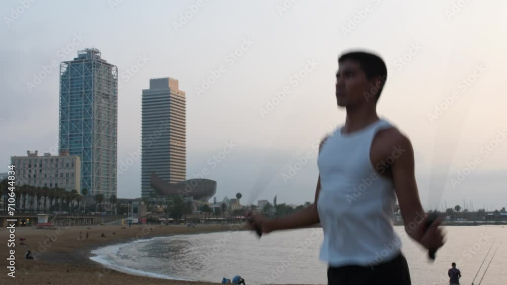 Young latino man exercising jumping the rope during sunrise by the beach Young latino man exercising jumping the rope during sunrise by the beach