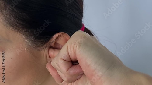 Woman plugs ear with finger and itchy ear. Otitis media and hearing problems in adult photo