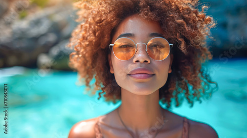Portrait of young black woman with curly hair wearing sunglasses. photo