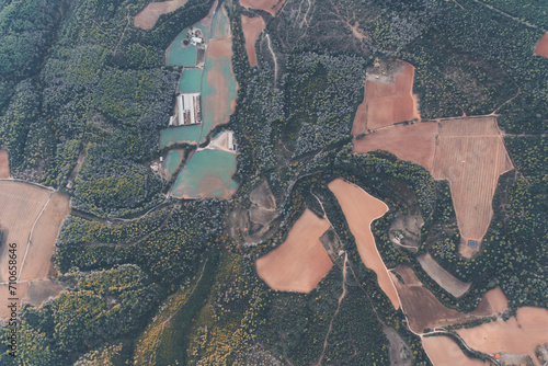 Aerial view of La Garrotxa landscape with bushes, meadows and patches. View from above of pinewood forest at La Garrotxa Volcanic Natural Park.