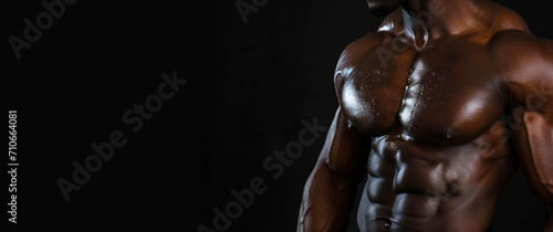 Strong muscular male posing against black background, cropped close up shot © piai