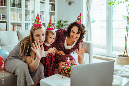 Happy lesbian couple celebrating daughter birthday at home photo