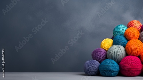 Rainbow wool yarn balls on gray background with ample text space for design or advertising. photo