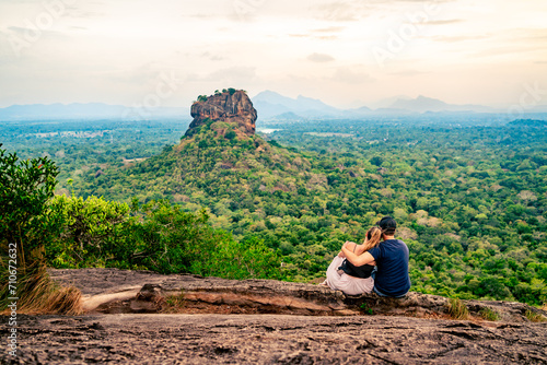 Couple in Sigiriya, rock view. Woman and man, summer travel. People on vacation in Sri Lanka. Beautiful nature with green landscape and mountains. Romance on Pidurangala. Honeymoon tourism. photo