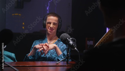 A gay man on a podcast is talking to the host of a radio show, smiling. Streaming for social networks, blogging. Blog topic: LGBT and transgender, homosexuals. Professional recording studio. photo