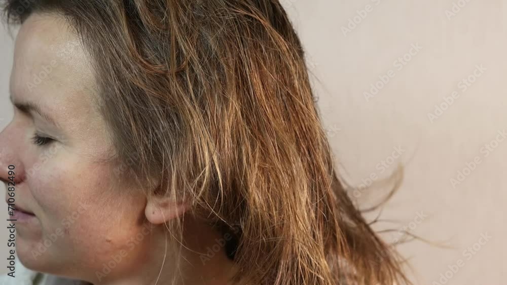 Woman with closed eye dries her hair with a hair dryer. Dry eyes and hair problem. Woman with closed eye dries her hair with a hair dryer. Dry eyes and hair problem.