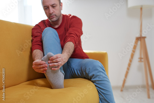 Man with ankle and foot pain at home.