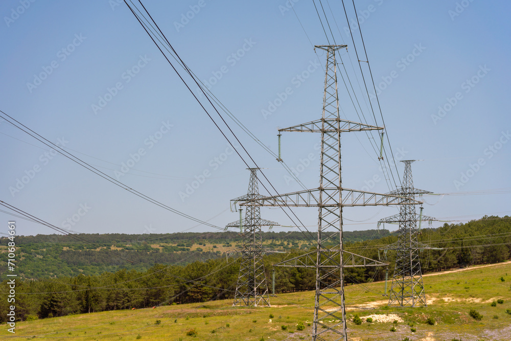 High voltage towers Electric pole. Power line support with wires for electricity transmission. High voltage grid tower with wire cable at distribution station. Energy industry, energy saving