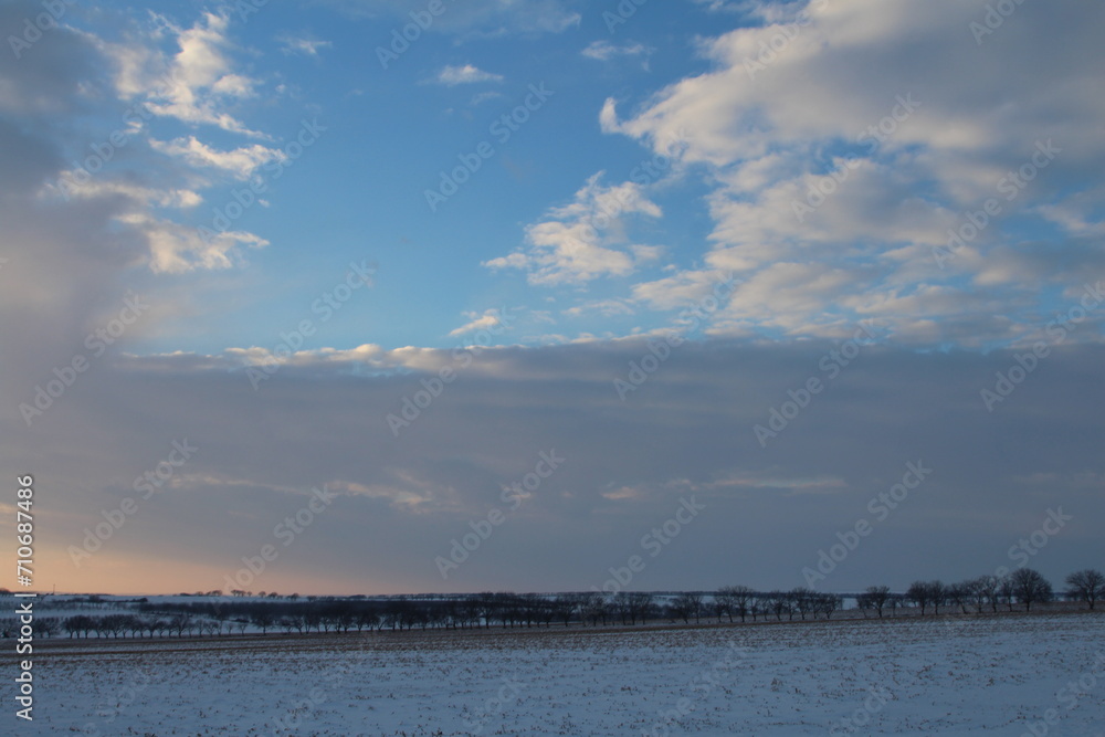 A snowy field with clouds