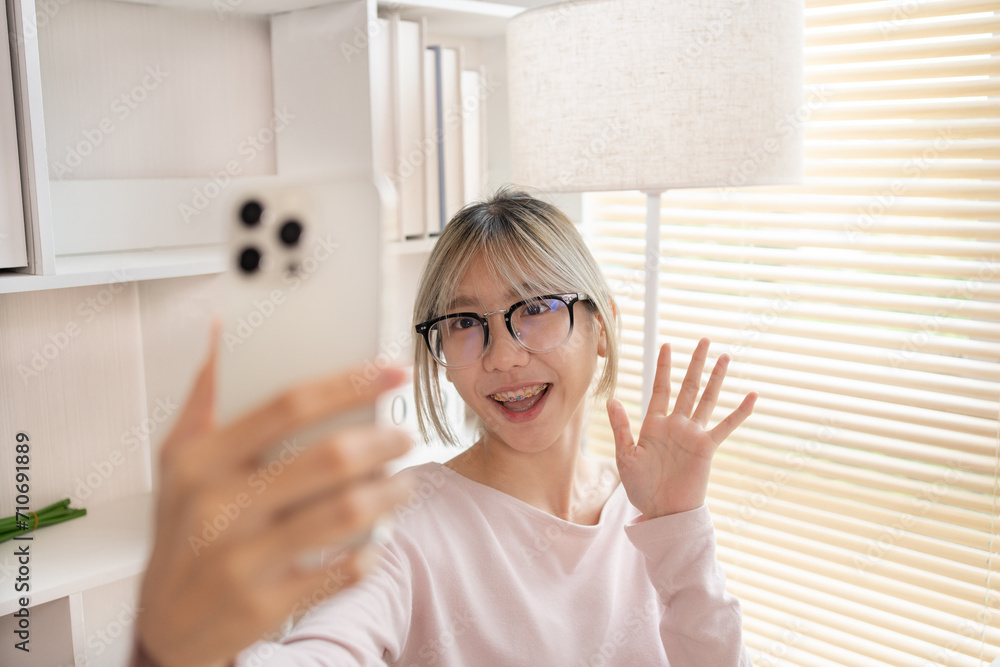 Say hi, Young woman uses her mobile phone to take a selfie of herself, Take a picture of yourself, Confidence and Self-Expression, Beaming. Say hi, Young woman uses her mobile phone to take a selfie of herself, Take a picture of yourself, Confidence and Self-Expression, Beaming.