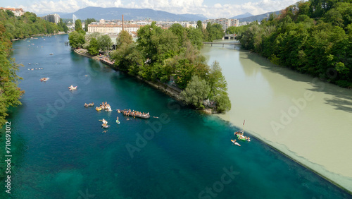 Fascinating confluence of different color river Rhone and river Arve in Geneva, Switzerland. Holidaymakers floating down blue Rhone river.