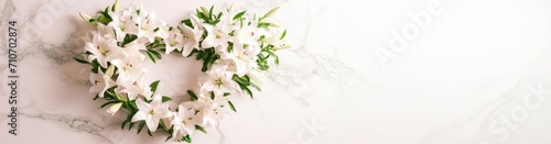 memorial bouquet of white lilies. heart shaped flower arrangement. on white marble   horizontal wallpaper with large copy space for text. wedding Condolence, grieving card, wedding , funerals, support