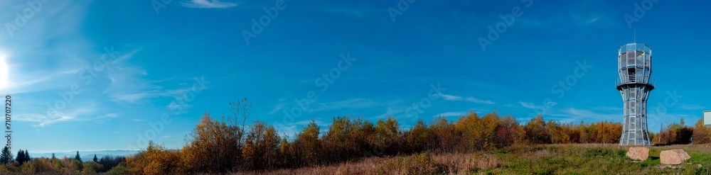 Observation tower, a landmark in the mountains against the background of an autumn forest. Panoramic view of natural landscape with green forest Observation tower, a landmark in the mountains against the background of an autumn forest. Panoramic view of natural landscape with green forest
