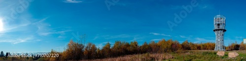 Observation tower, a landmark in the mountains against the background of an autumn forest. Panoramic view of natural landscape with green forest