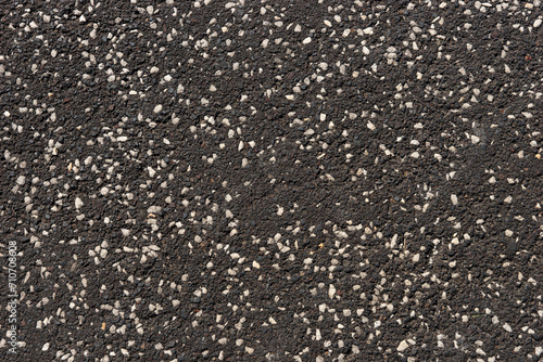 Dark asphalt with small white pebbles. Asphalt texture