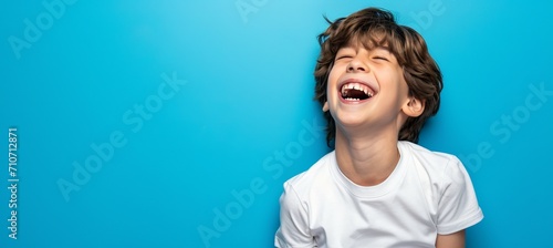 Smiling white american boy model with clean teeth on blue background, ideal for ads and web design
