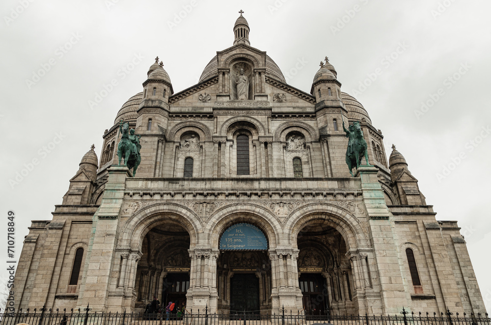 The Roman Catholic church Sacr-Coeur Basilica in Montmartre with the bronze statues of Joan of Arc and Louis IX on either side, Romano-Byzantine architecture constructed in travertine. Space for text,