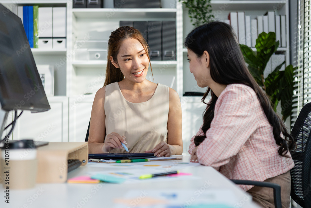 Obraz premium Asian two woman business office discussing financial accounting using tablet working company profits, Female manager brainstorming examine document finance.