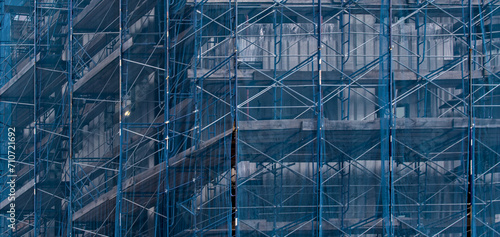 Wallpaper Mural building under construction covered in blue mesh tarp protective wrap (safety debris netting during demolition work) scaffolding high rise commercial architecture Torontodigital.ca