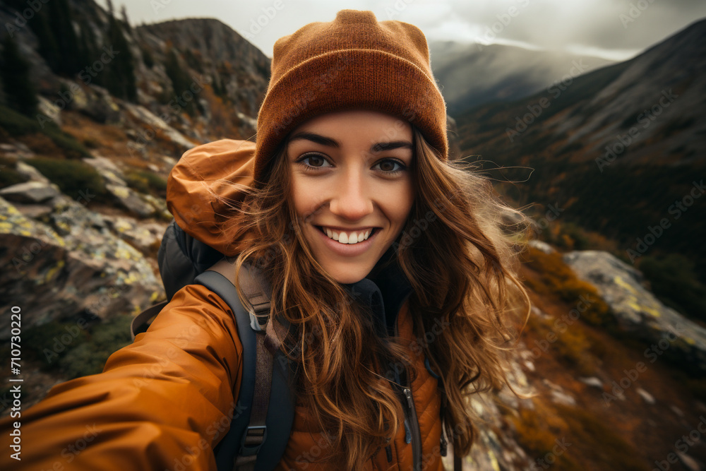 Young woman hiker taking selfie with mobile phone in the mountains.