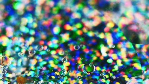 Oil bubbles. Gel fluid. Defocused transparent round droplets floating motion on colorful glitter texture abstract art background.