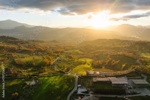 Aerial view of a mountains and hills landscape with vineyard and countryside houses at sunset in autumn colours, Irpinia, Avellino, Campania, Italy. photo