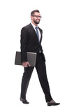 side view. smiling businessman with laptop stepping forward