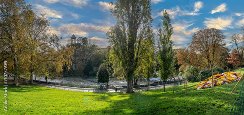 Paris, France - 11 11 2023: Park des Buttes Chaumont. View the central part of the park with footbridge, belvedere island, Temple of the Sibyl and the lake under construction due to renovation.