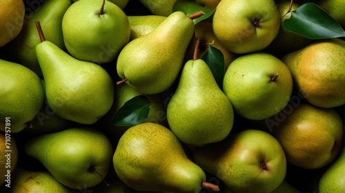  a pile of green pears and pears with a leaf on top of one of the pears and another of the pears on the other.