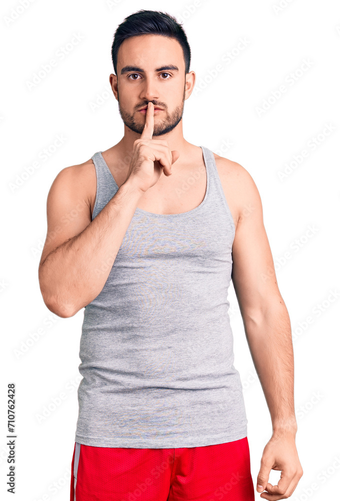 Young handsome man wearing swimwear and sleeveless t-shirt asking to be quiet with finger on lips. silence and secret concept. Young handsome man wearing swimwear and sleeveless t-shirt asking to be quiet with finger on lips. silence and secret concept.