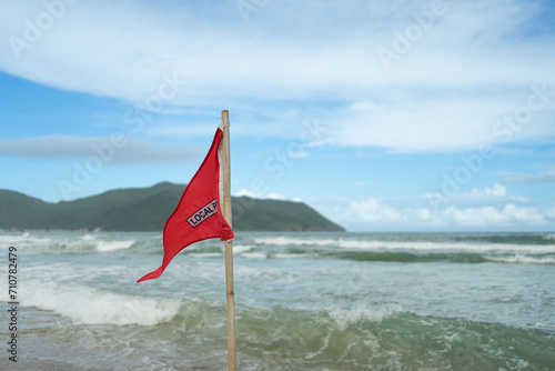 Red flag on the beach in Brazil indicating danger, inappropriate swimming conditions; high risk.