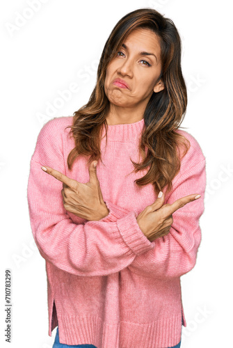 Young hispanic woman wearing casual clothes pointing to both sides with fingers, different direction disagree