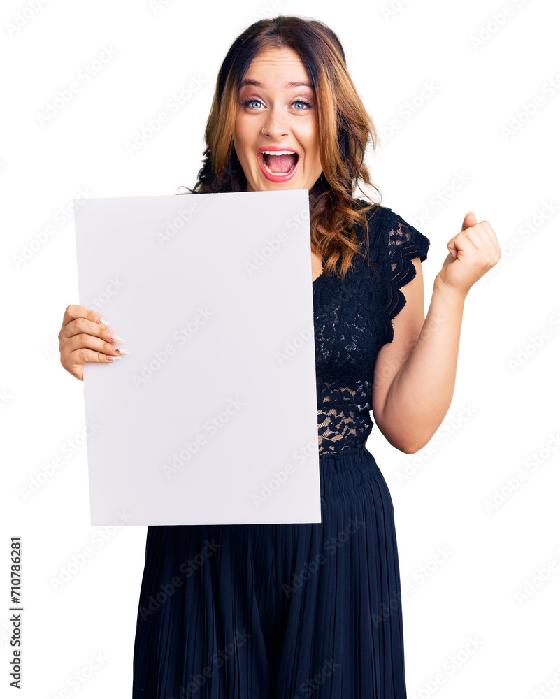 Young beautiful caucasian woman holding cardboard banner with blank space screaming proud, celebrating victory and success very excited with raised arms Young beautiful caucasian woman holding cardboard banner with blank space screaming proud, celebrating victory and success very excited with raised arms