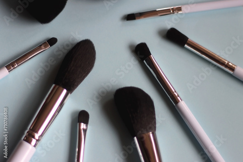 Various make up brushes on bright blue background. Selective focus.